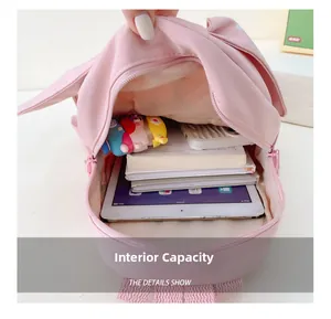 Detailed interior view showing large capacity for books and tablet in pink backpack