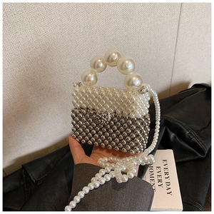 Detail of a handmade mini pearl crossbody bag with silver beaded color blocking design