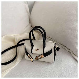 Détail du mini sac bandoulière en cuir bicolore avec fermoir doré et sangle noire