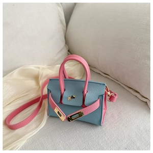Détails du mini sac Kelly bicolore bleu et rose avec boucles dorées et texture cuir grainé
