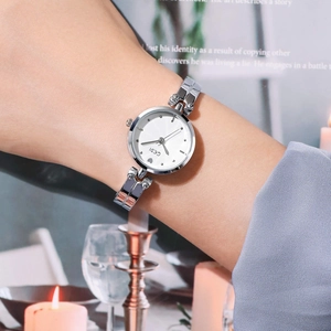 Montre quartz argentée pour femme avec détail de cœur et cadran blanc sur un poignet
