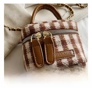 Detail of wool plaid mini bucket bag featuring double zippers and leather handle