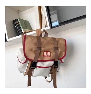 Detail of khaki and off-white backpack with red piping and adjustable buckle straps