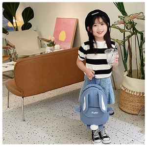 Detail of cute blue rabbit backpack featuring soft plush tail and 3D long bunny ears