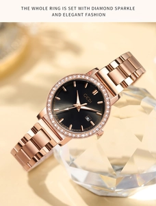 Detail of rose gold watch with black dial and crystal bezel resting on clear glass