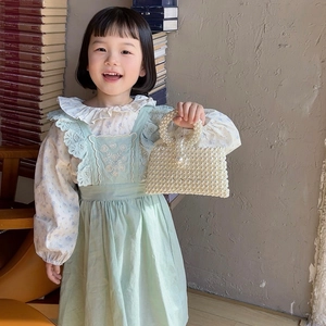 Kids pearl beaded handbag with round handle and floral dress on young model
