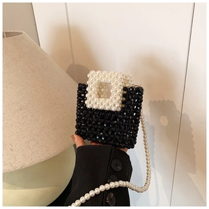 Close-up of mini handmade beaded purse with black and white pearls and long chain