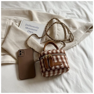 Detail of plaid wool mini bucket bag with chain strap and matching phone case set