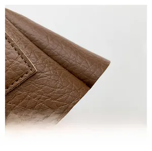 Close-up of premium brown lychee pattern leather and detailed stitching of the bag