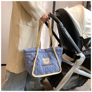 Quilted blue canvas tote bag with bear embroidery shown with a baby stroller scene