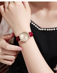 Detail of luxury women watch featuring crystal bezel and red crocodile leather strap