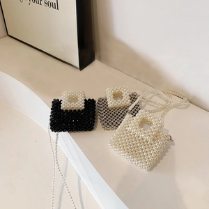 Close-up of handmade beaded mini square bags with pearl straps in three color options