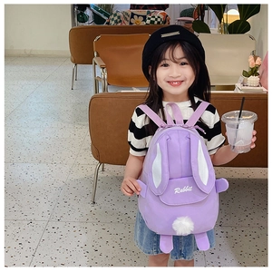 Detail of purple cartoon rabbit kids backpack showing embroidery and cute plush ball
