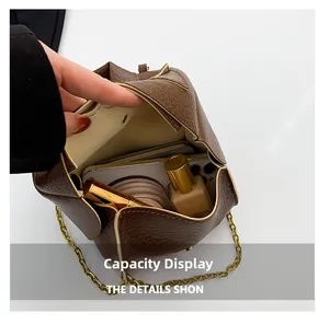 Brown lychee leather bag capacity view holding smartphone and makeup essentials
