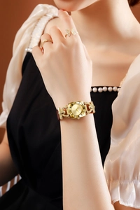Detailed macro view of vintage square gold watch with brown leather strap and Roman numerals
