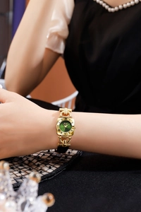 Detail of Gedi gold case watch with green sunray dial and Roman numerals on wrist