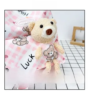 Gros plan sur le petit ours en peluche d'un sac à dos rose à carreaux pour enfant