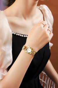 Close-up of elegant gold square watch with chain strap and minimalist white dial