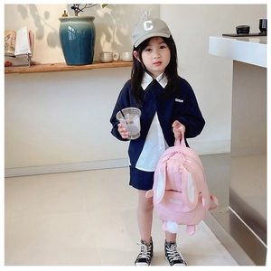 Detail of pink canvas rabbit backpack with 3D long ears and white pom-pom tail