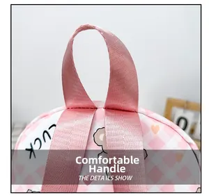 Détail de la poignée en nylon rose sur un sac à dos en toile à carreaux avec ours
