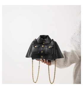 Detail of creative jacket shaped black leather bag with gold buttons and chain strap