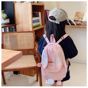 Pink cartoon rabbit backpack for girls featuring plush ears and adjustable straps