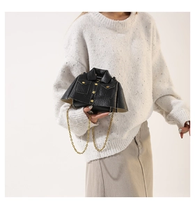 Detail view of mini jacket-shaped crossbody bag with lychee texture and gold chain strap