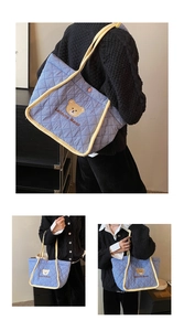Close-up of quilted canvas tote with bear embroidery and yellow rope trim detail