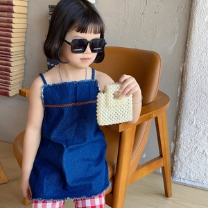 Girl's denim dress with trendy white pearl beaded handbag and square sunglasses