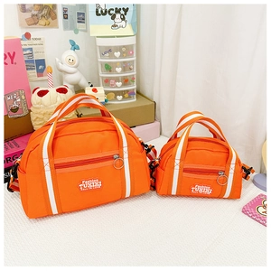 Makrodetail der orangefarbenen Nylon-Kindertasche mit Modeetikett und weißen Trägern