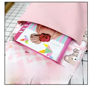 Vue détaillée de la poche avant sur un sac à dos rose pour enfant avec motif d'ours