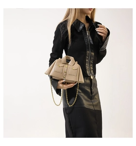 Detail of creative jacket-shaped crossbody bag with gold chain and lychee texture
