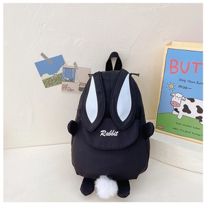 Detail of black rabbit backpack featuring fluffy tail and long bunny ears with white lining