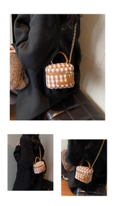 Detail view of mini plaid box bag with brown leather trim and golden metal chain strap