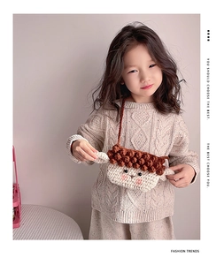 Détail d'un sac bandoulière agneau au crochet pour enfant avec pompons marrons