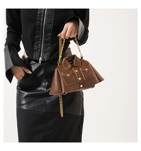 Detail of creative leather jacket bag in brown with lychee texture and gold chain link