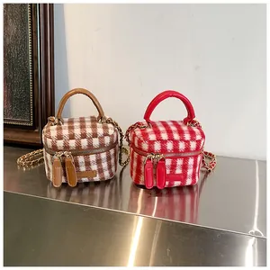 Detail of tweed plaid bucket bags showing soft fabric texture and chain straps