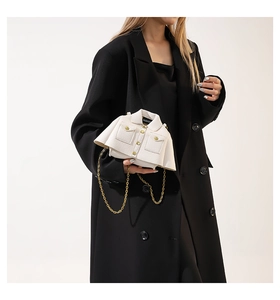 Detail of creative white jacket-shaped chain bag with litchi texture on black blazer