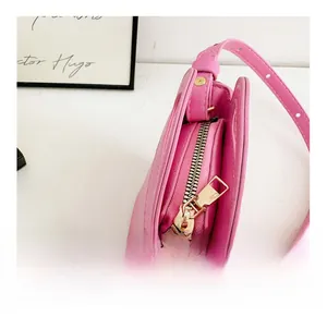 Close-up of smooth gold metal zipper and pink leather texture on kids mini handbag