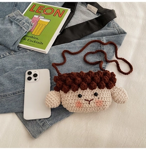 Vue détaillée d'un porte-monnaie mouton au crochet sur denim, montrant la texture tricotée