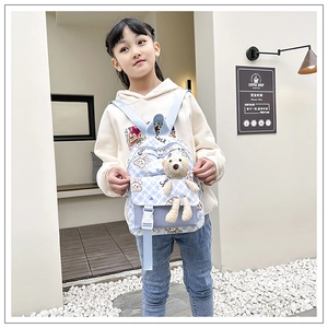 Détail du sac à dos enfant à carreaux bleus avec motif d'ours et peluche mignonne