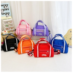 Detailansicht bunter Kinder-Schultertaschen aus Nylon mit Streifen und Stickereien
