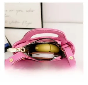 Internal view of pink mini plaid handbag showing storage capacity and zipper detail