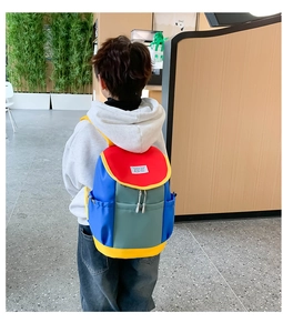 Detail of multi-pocket kids backpack with color-block canvas and fashion label