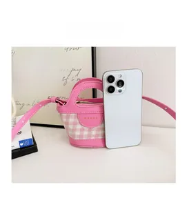 Pink plaid mini bag shown next to a smartphone for a scale size comparison