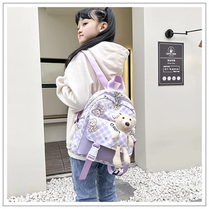 Détail du sac à dos enfant à carreaux violets avec motif ours et peluche décorative