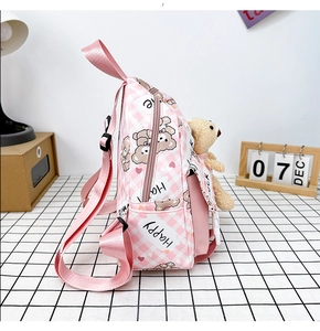Détail du sac à dos en toile à carreaux roses avec motif ours et peluche sur le côté