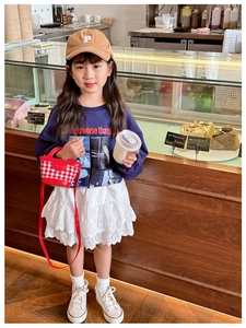 Detail of red plaid kids handbag paired with embroidery cap and stylish navy sweatshirt