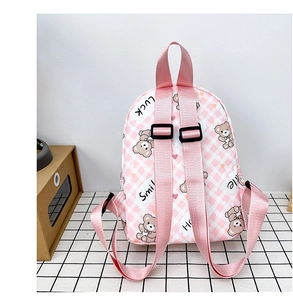 Gros plan d'un sac à dos rose à carreaux pour enfant avec imprimé ours et bretelles