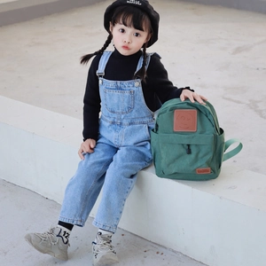 Kid's canvas backpack in dark green featuring a smiley face patch for school and travel